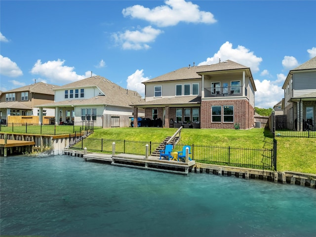 back of house with a lawn, a balcony, and a water view