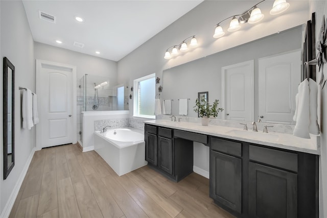 bathroom featuring shower with separate bathtub, vanity, and hardwood / wood-style floors