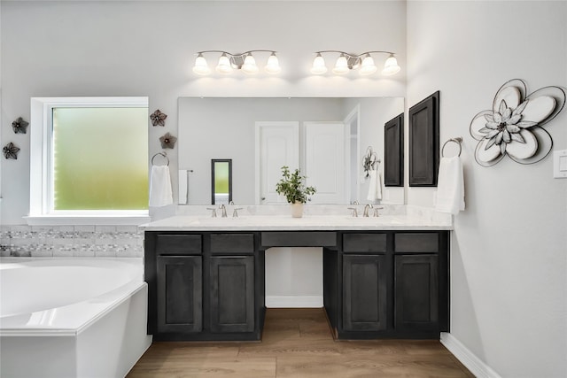 bathroom featuring wood-type flooring, vanity, and a tub to relax in