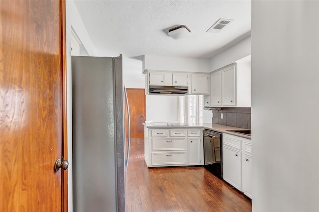 kitchen with white cabinetry, black dishwasher, backsplash, kitchen peninsula, and stainless steel fridge