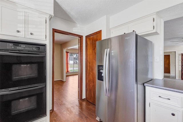 kitchen featuring white cabinetry, ceiling fan, dark hardwood / wood-style flooring, stainless steel refrigerator with ice dispenser, and double oven