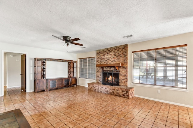 unfurnished living room with a fireplace, light tile patterned floors, a textured ceiling, and ceiling fan