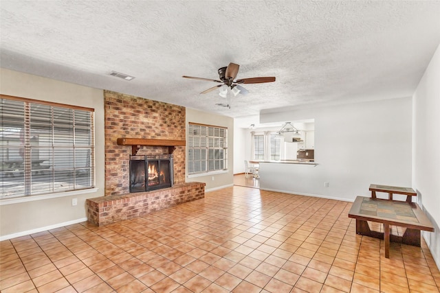 unfurnished living room with a fireplace, light tile patterned floors, a textured ceiling, and ceiling fan