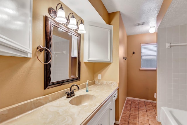 bathroom with a bathing tub, tile patterned floors, a textured ceiling, toilet, and vanity