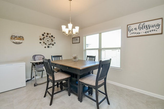 tiled dining room featuring plenty of natural light and an inviting chandelier