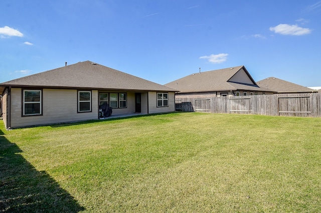 rear view of property with a yard