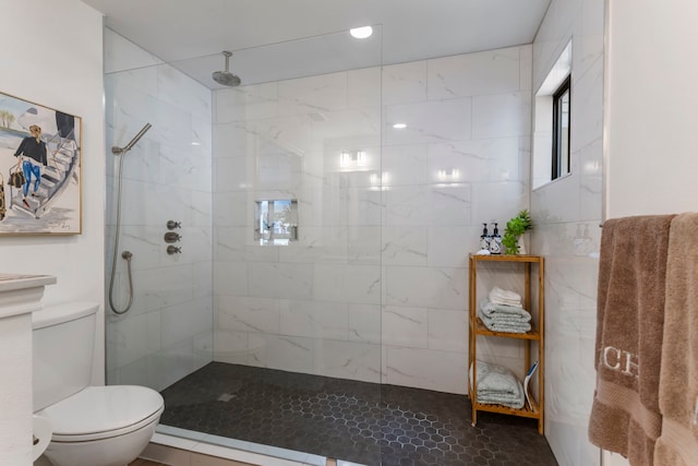 bathroom featuring tiled shower and toilet