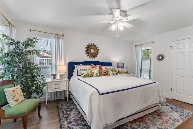 bedroom featuring ceiling fan, multiple windows, and hardwood / wood-style flooring