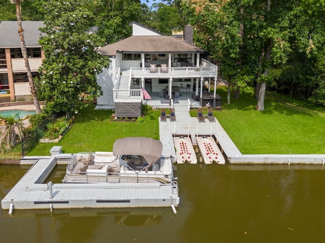 rear view of property with a yard and a deck with water view