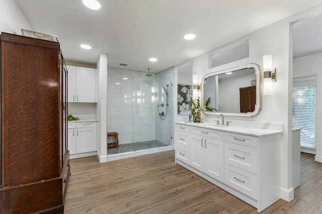 bathroom featuring tiled shower, hardwood / wood-style floors, and vanity