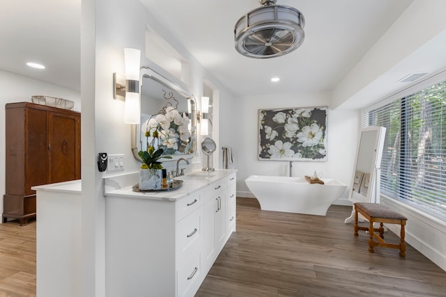 bathroom with hardwood / wood-style flooring, a bathtub, and vanity