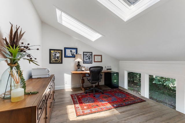 home office with lofted ceiling with skylight and dark wood-type flooring