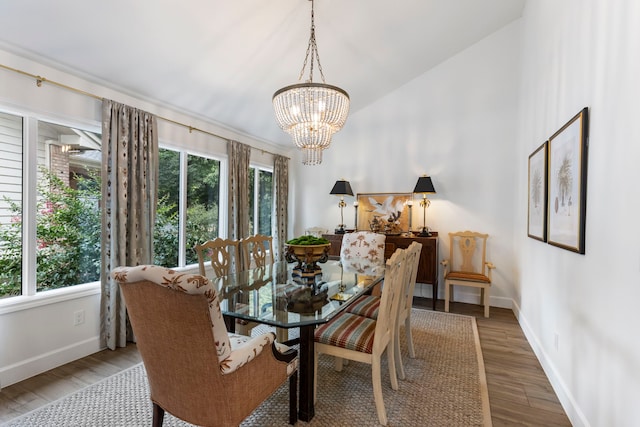 dining space featuring an inviting chandelier, a wealth of natural light, lofted ceiling, and wood-type flooring