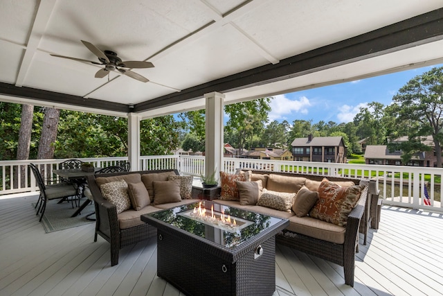 wooden deck with ceiling fan and an outdoor living space with a fire pit