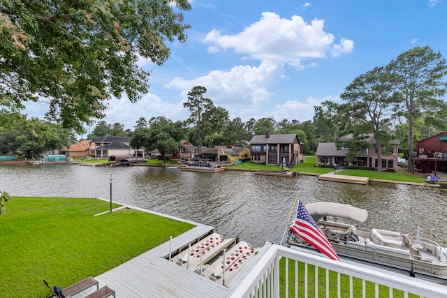 view of dock with a water view and a lawn