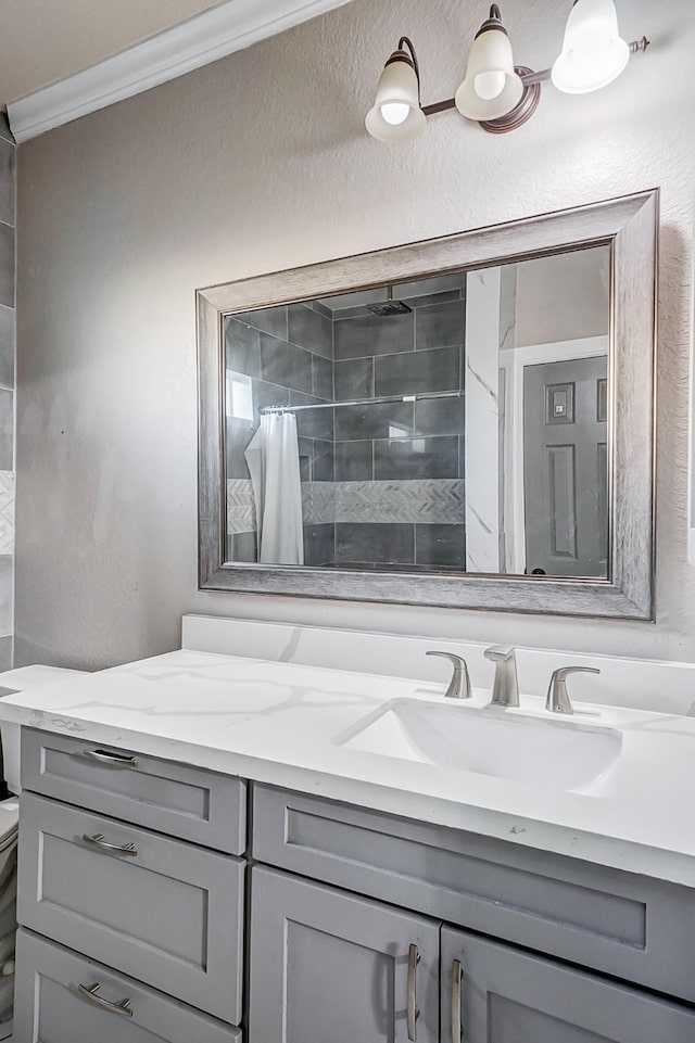 bathroom featuring vanity, toilet, curtained shower, and ornamental molding