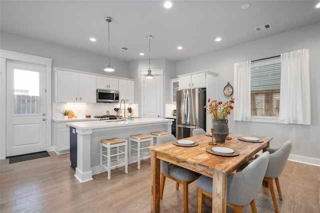 dining space featuring light hardwood / wood-style flooring and a healthy amount of sunlight