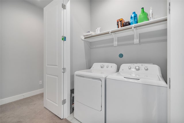 clothes washing area with washer and clothes dryer and light colored carpet