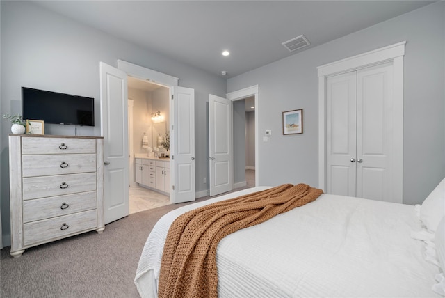 carpeted bedroom featuring connected bathroom and a closet