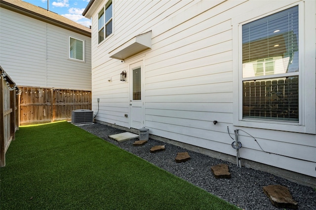 view of side of property with a yard and central AC unit