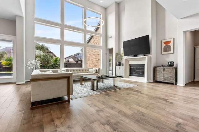 unfurnished living room featuring a towering ceiling and light hardwood / wood-style flooring