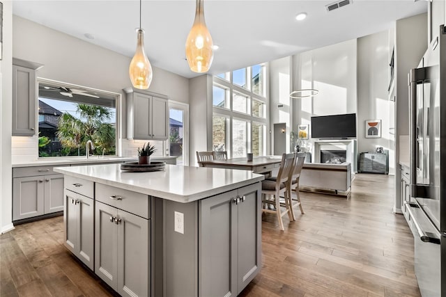 kitchen with decorative light fixtures, backsplash, and gray cabinets