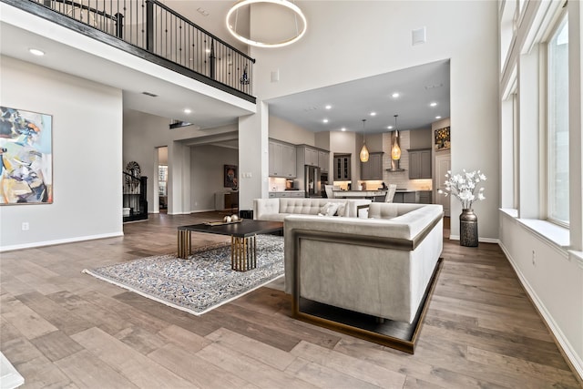 living room with hardwood / wood-style flooring and a towering ceiling