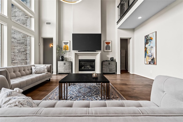 living room with dark wood-type flooring and a high ceiling