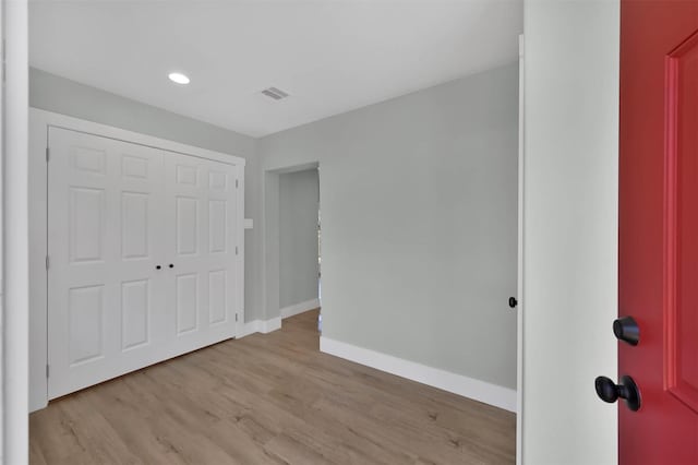 unfurnished bedroom featuring light hardwood / wood-style floors and a closet