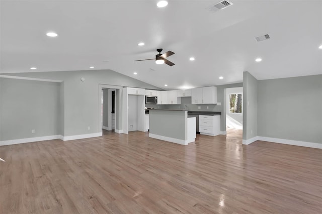 unfurnished living room with light wood-type flooring, vaulted ceiling, and ceiling fan