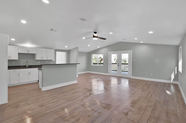 unfurnished living room with ceiling fan, sink, french doors, and light wood-type flooring