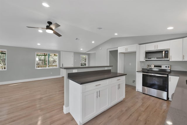 kitchen featuring stainless steel appliances, vaulted ceiling, ceiling fan, light hardwood / wood-style flooring, and white cabinets