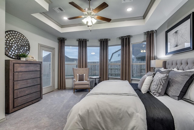 carpeted bedroom featuring a raised ceiling, ceiling fan, and crown molding