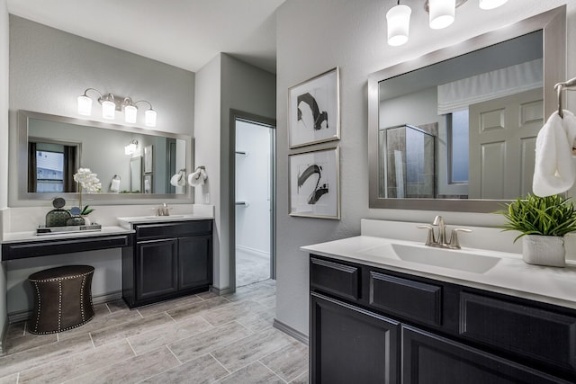 bathroom with a shower with door and vanity