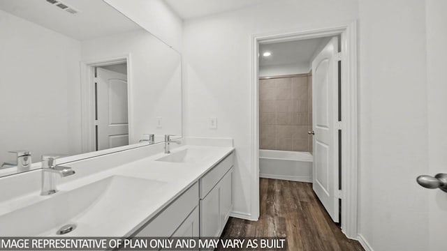 bathroom featuring tiled shower / bath combo, wood-type flooring, and vanity