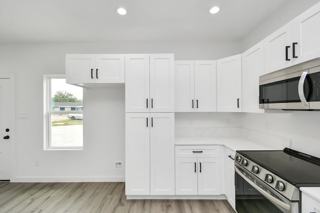 kitchen featuring white cabinets, stainless steel appliances, and light hardwood / wood-style floors