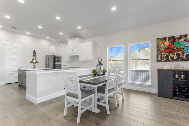 kitchen with white cabinets, sink, appliances with stainless steel finishes, and a breakfast bar area