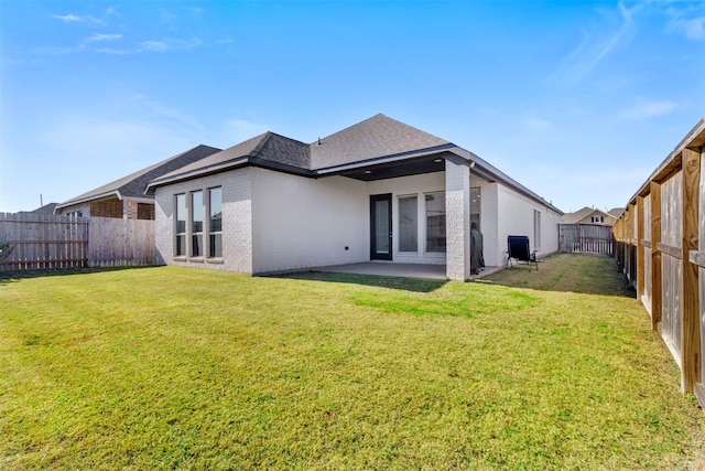 rear view of house with a yard and a patio