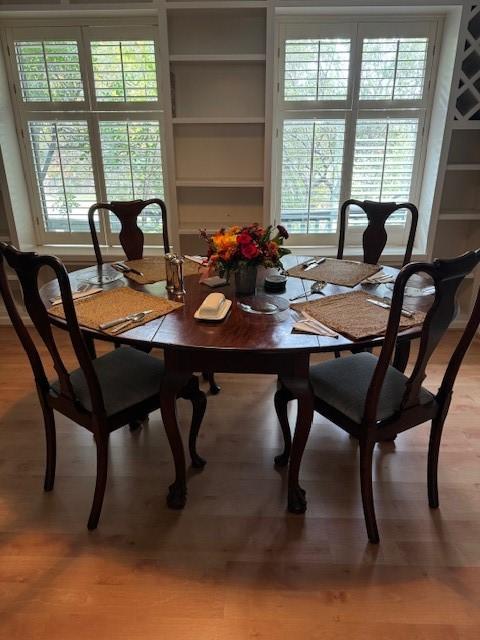 dining area with light wood-type flooring and built in features