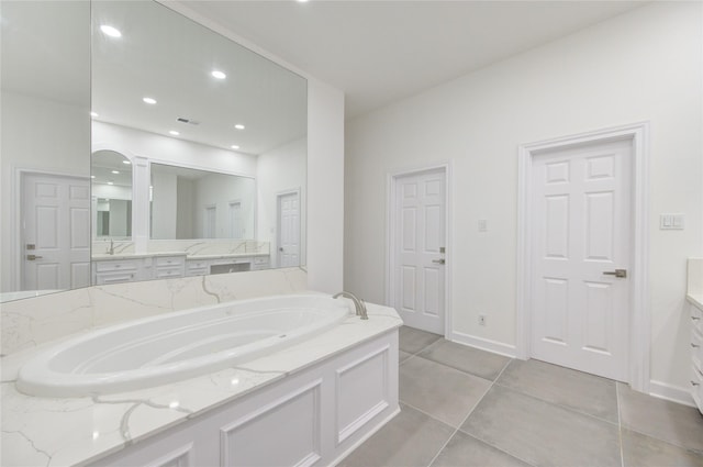 bathroom with tile patterned flooring, a washtub, and vanity