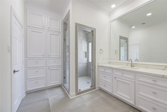 bathroom with tile patterned flooring, vanity, a shower with door, and crown molding