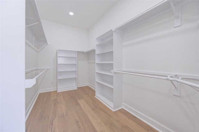 walk in closet with light hardwood / wood-style floors