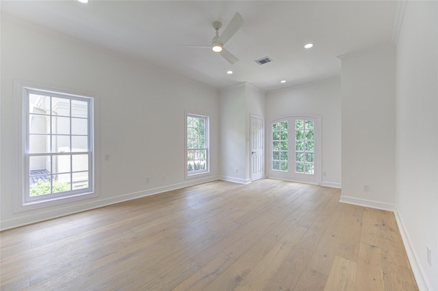 spare room with light hardwood / wood-style floors, a wealth of natural light, ornamental molding, and ceiling fan