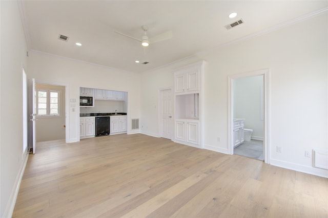 unfurnished living room featuring light wood-type flooring, ceiling fan, ornamental molding, and sink