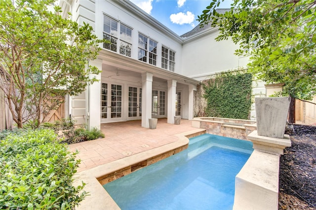 view of swimming pool featuring french doors, a hot tub, and a patio area