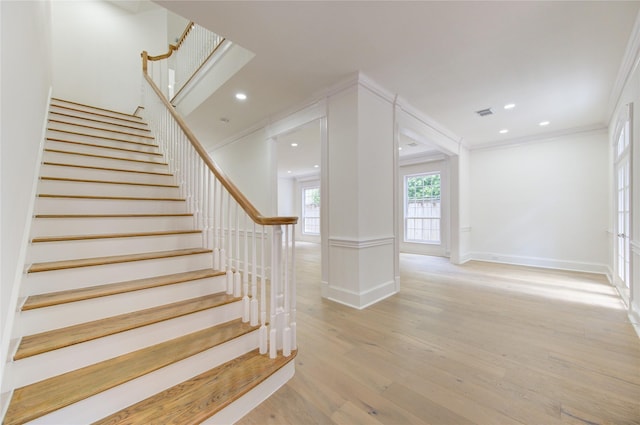 staircase with crown molding and hardwood / wood-style floors