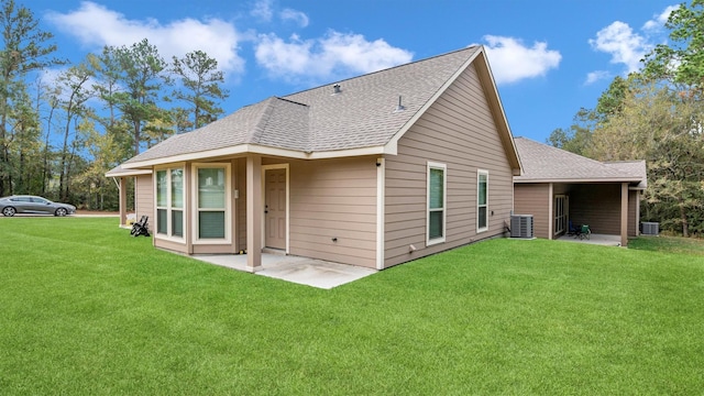 rear view of property featuring central air condition unit, a patio area, roof with shingles, and a yard