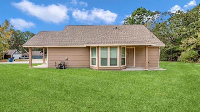 rear view of property featuring a shingled roof and a yard