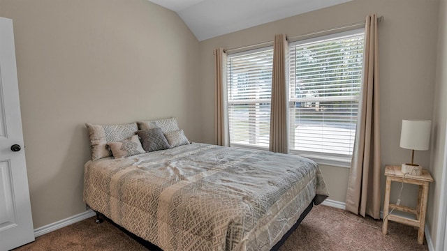 carpeted bedroom with lofted ceiling and baseboards