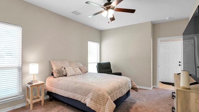 bedroom with baseboards, a ceiling fan, visible vents, and light colored carpet